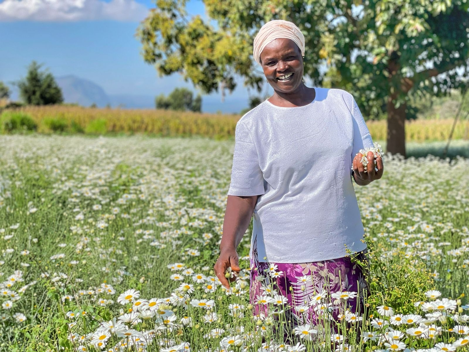 A smiling person standing in a flower field