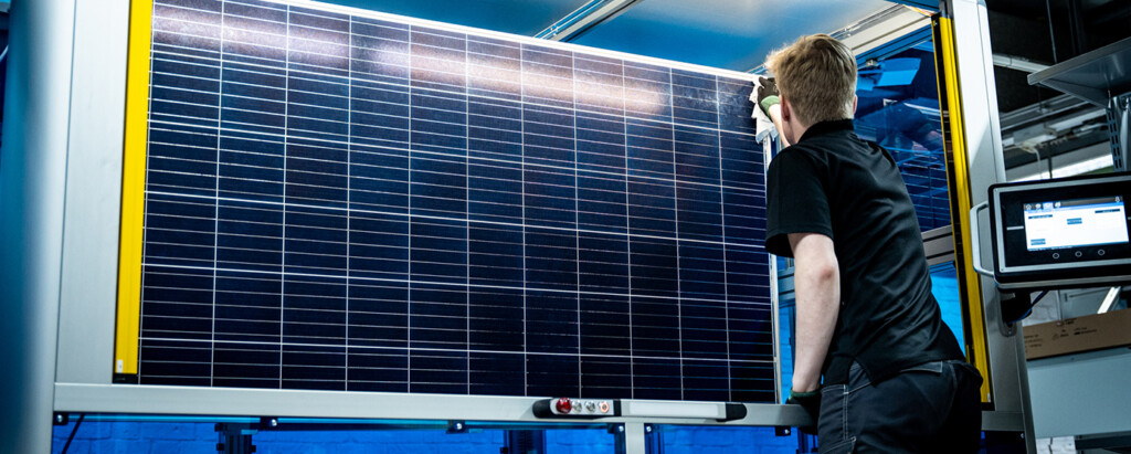 Henkilö Salo Techin tehtaalla pyyhkii aurinkopaaneelin pintaa